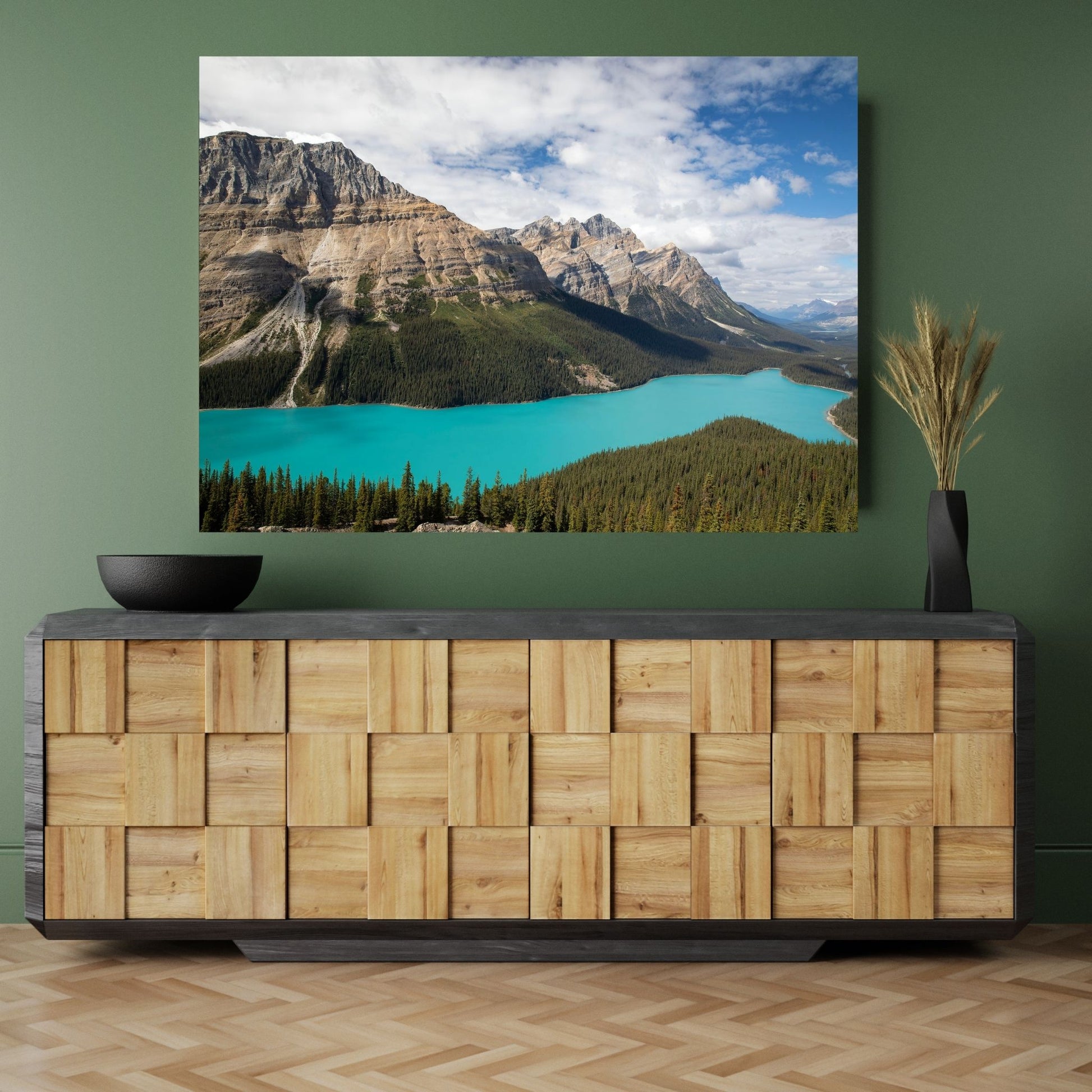 A chic green room featuring a stylish wooden credenza, complemented by a large fine art photograph of Peyto Lake in Banff National Park. The stunning turquoise lake adds a vivid splash of color to the space, perfectly contrasting with the natural wood tones and muted green walls. This captivating landscape art invites serenity and natural beauty, creating a calming focal point for a modern and sophisticated interior design.