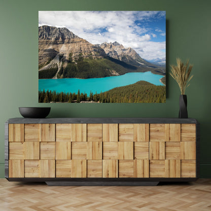 A chic green room featuring a stylish wooden credenza, complemented by a large fine art photograph of Peyto Lake in Banff National Park. The stunning turquoise lake adds a vivid splash of color to the space, perfectly contrasting with the natural wood tones and muted green walls. This captivating landscape art invites serenity and natural beauty, creating a calming focal point for a modern and sophisticated interior design.