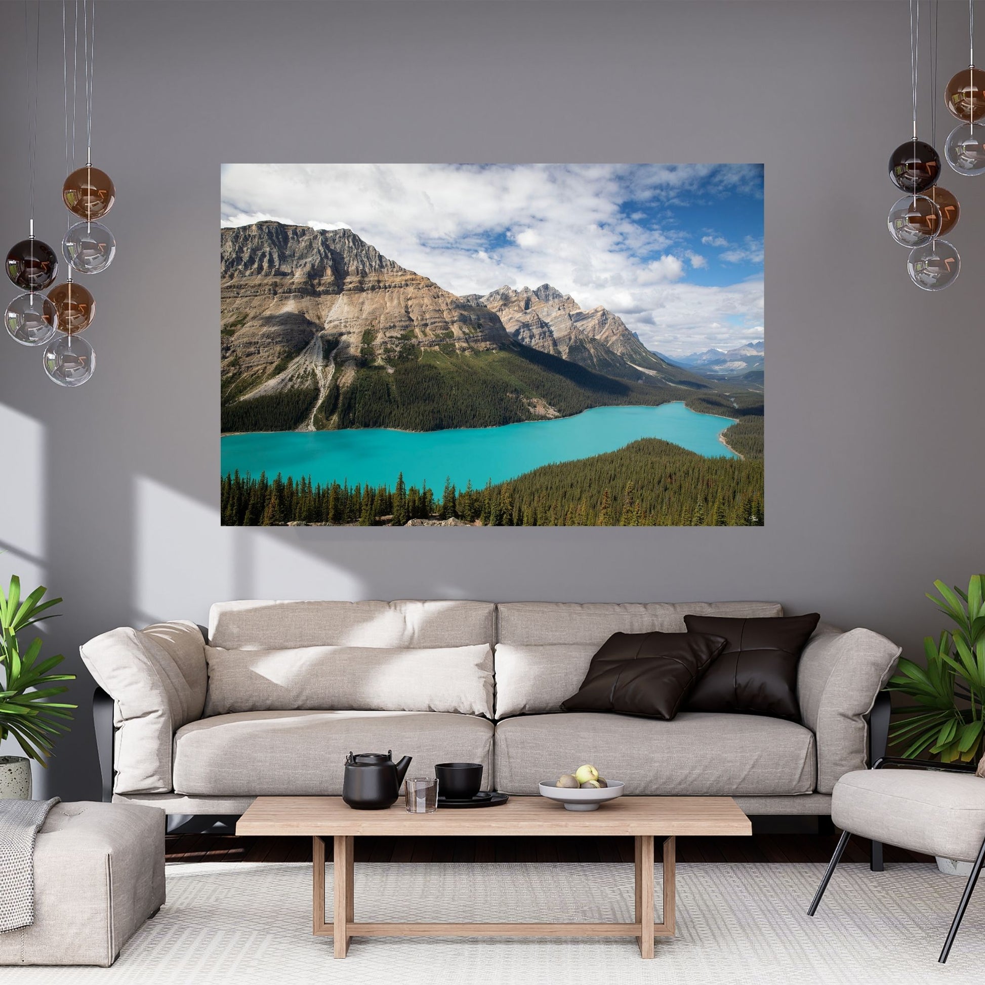 A modern grey living room featuring a large fine art photograph of Peyto Lake in Banff National Park. The vibrant turquoise waters of the lake bring a striking contrast to the neutral tones of the couch and decor, adding a touch of nature’s beauty to this sleek, minimalist space. The elegant hanging lights and subtle greenery further complement the calm, serene atmosphere, making this wall art a captivating centerpiece in the room, perfect for relaxation and inspiration.