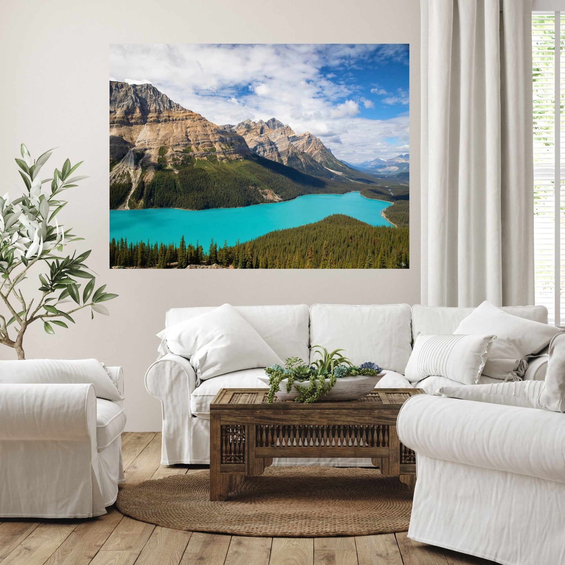 A serene white living room featuring a large fine art photograph of Peyto Lake in Banff National Park, Canada. The vibrant turquoise waters and rugged mountain landscape bring a sense of calm and natural beauty to the space, creating an elegant focal point above the couch.