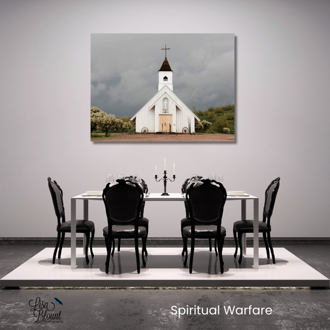 Fine art photography print of a rustic white country church under dramatic stormy skies, titled 'Spiritual Warfare’ hanging in a minimalistic black white grey dining room.